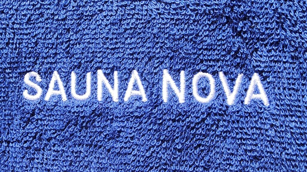 瞑想サウナポンチョの綿パイル生地のアップ。SAUNA NOVAのロゴが入っている